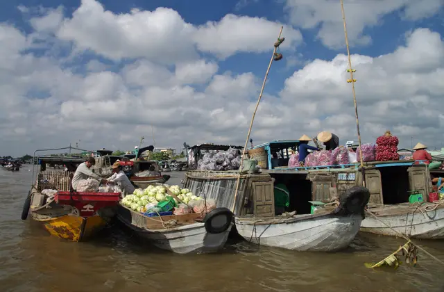 Produce boats crowded together at a floating market on the Mekong Delta