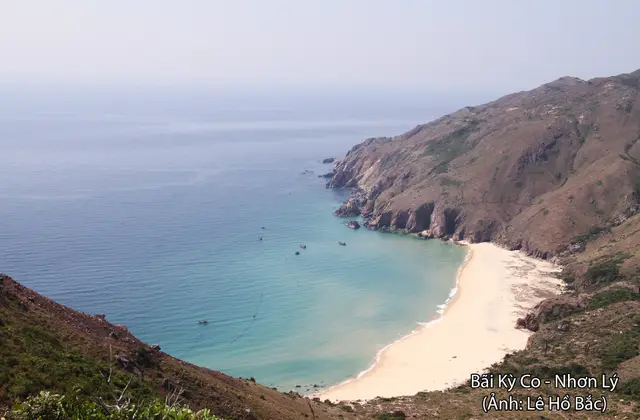 Turquoise cove and pale sand beach below a rugged headland near Quy Nhon